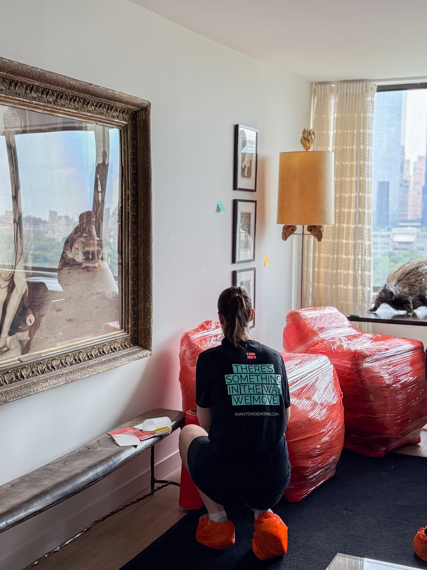 Avant-Garde Moving crew member wrapping furniture in a Manhattan apartment overlooking Central Park