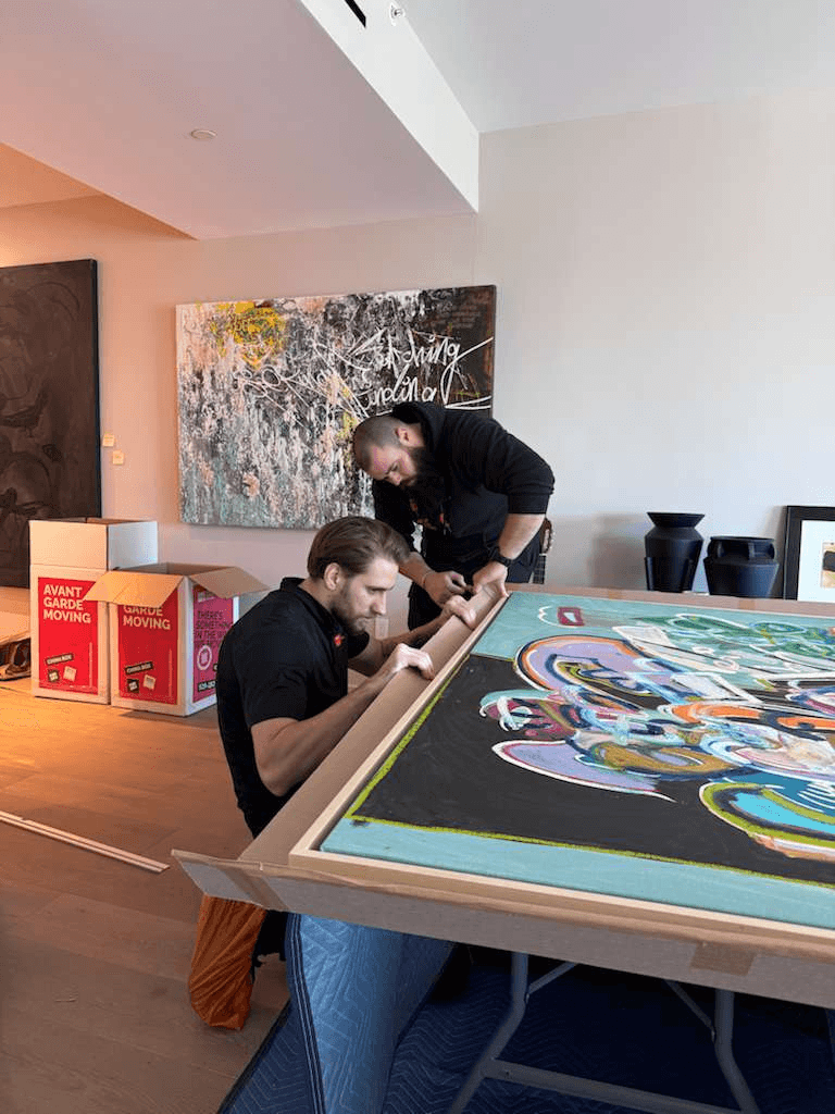 Avant-Garde art handlers preparing a large painting for custom crating in a Chelsea residence