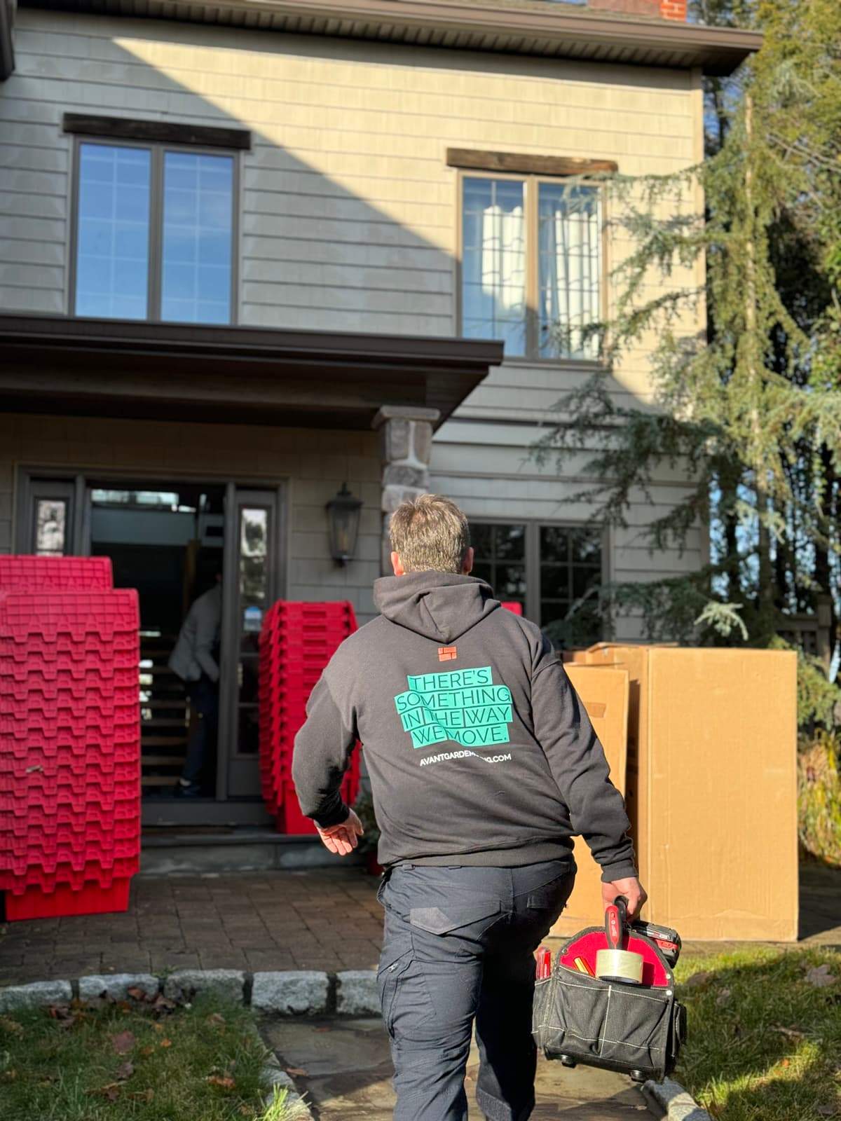 Greenpoint movers carrying furniture down a Polish-enclave rowhouse walk-up near Manhattan Avenue