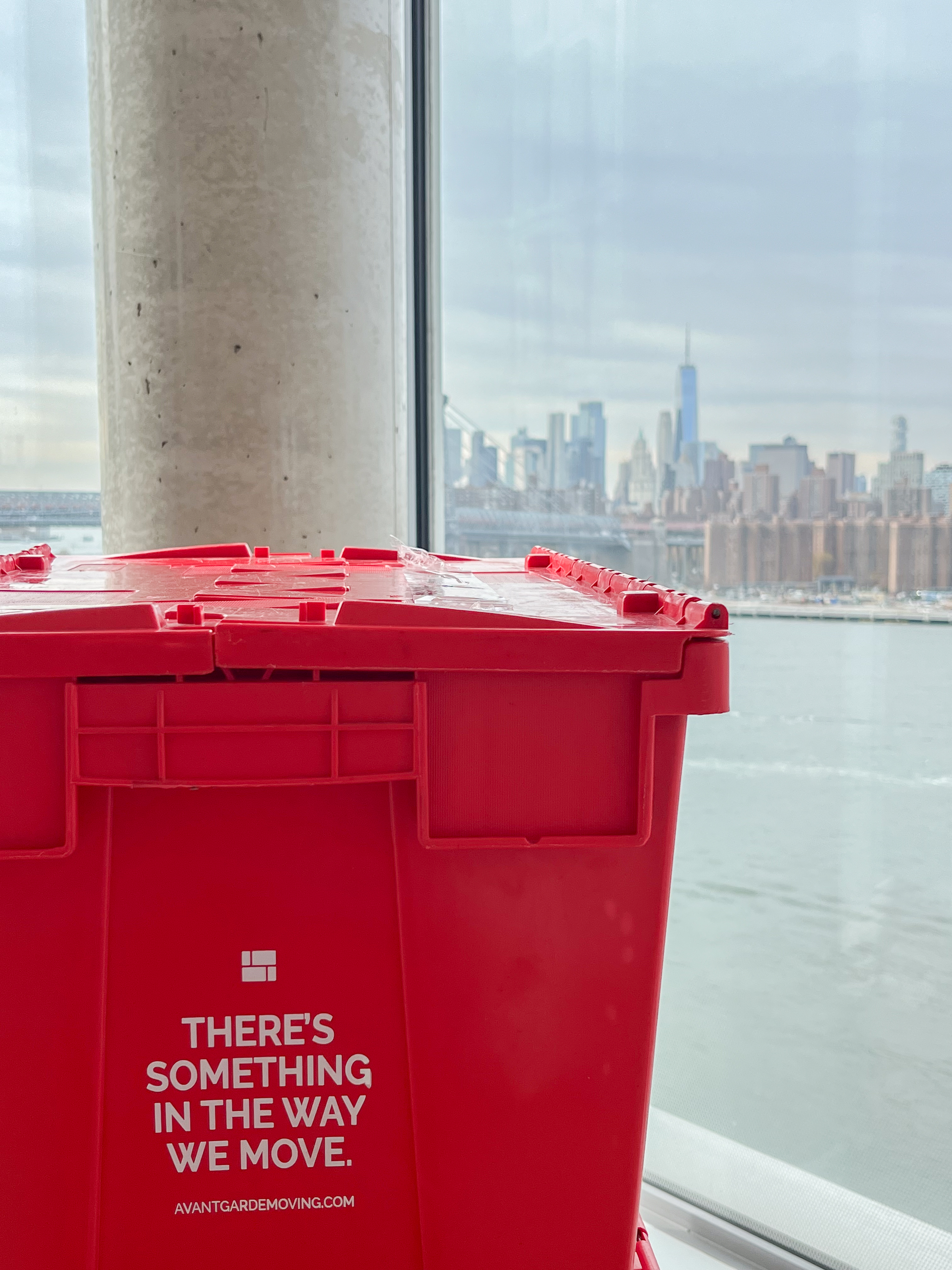 Red plastic moving bins with NYC skyline in background