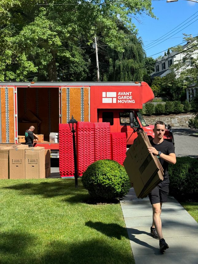 Professional moving team loading truck with proper equipment